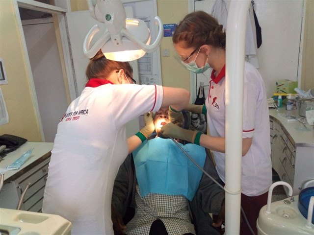 Anna Hübben (esq.) a extrair um dente. Kyra Kalbhen assiste-a na extração
